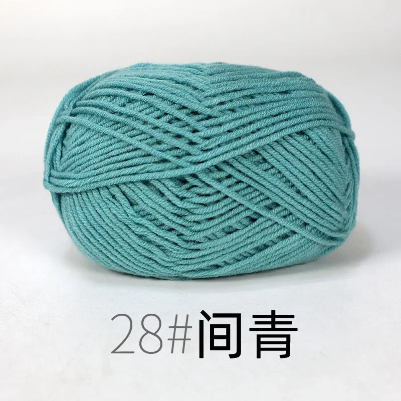 A ball of teal organic cotton 4ply knitting yarn labeled as size 28
