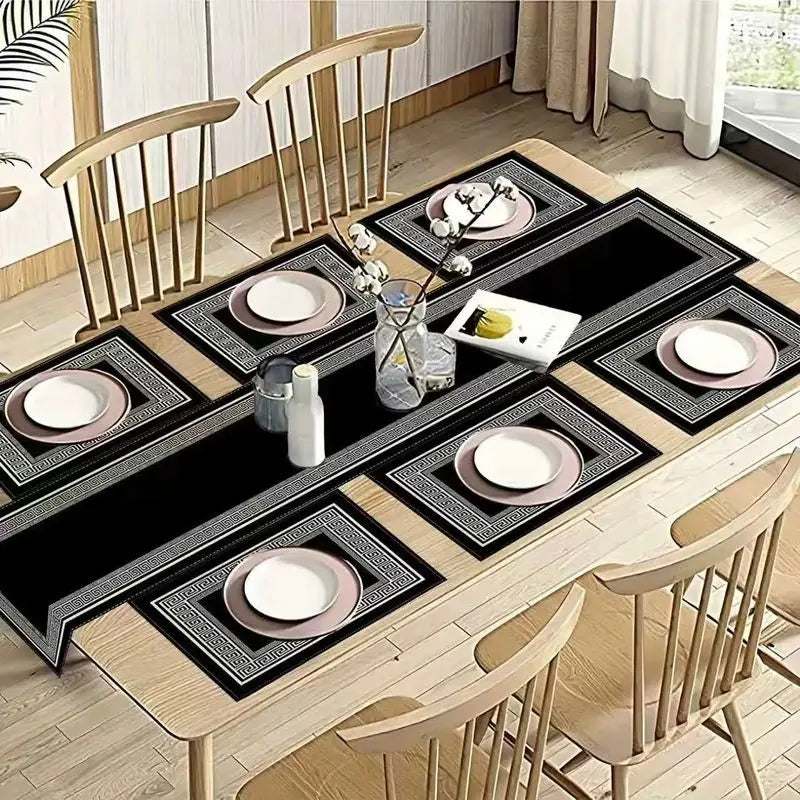 A wooden dining table set with black and white geometric placemats and tableware.