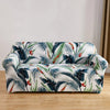 A sofa covered in a tropical leaf pattern featuring shades of blue, green, and white.