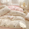 A set of three pink and white bedding pieces featuring bowknot embroidery on a duvet cover and pillows.