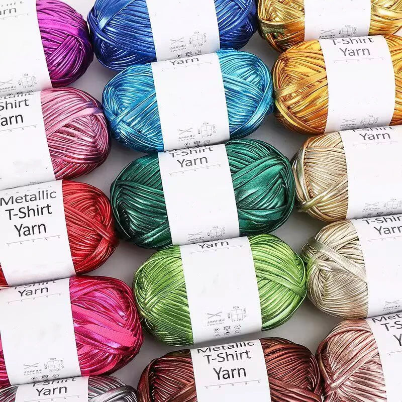 A collection of colorful metallic T-shirt yarn skeins in various shades including purple, blue, green, and gold.