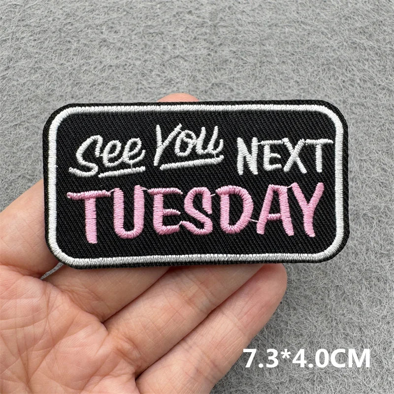 Black embroidered patch with pink text that reads See You Next Tuesday