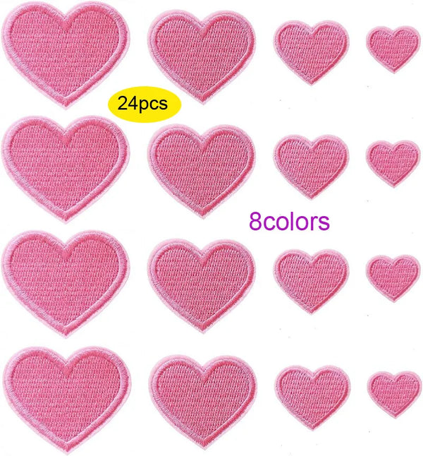 A collection of 24 pink iron-on love heart embroidered patches in various shades and sizes.