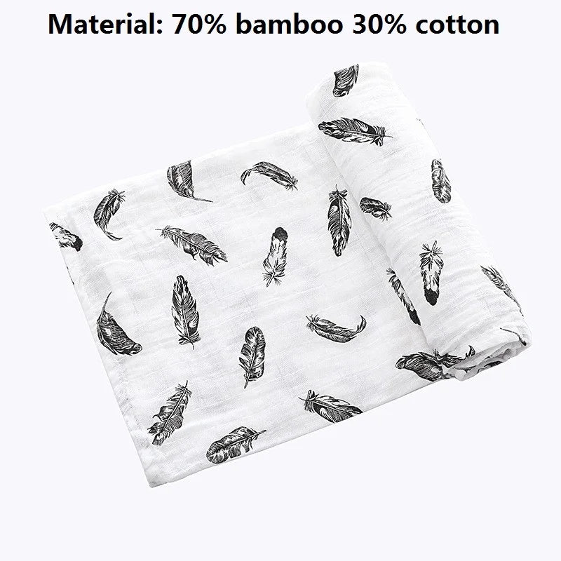 A white muslin swaddle blanket featuring a pattern of feather and leaf designs made from 70% bamboo and 30% cotton.