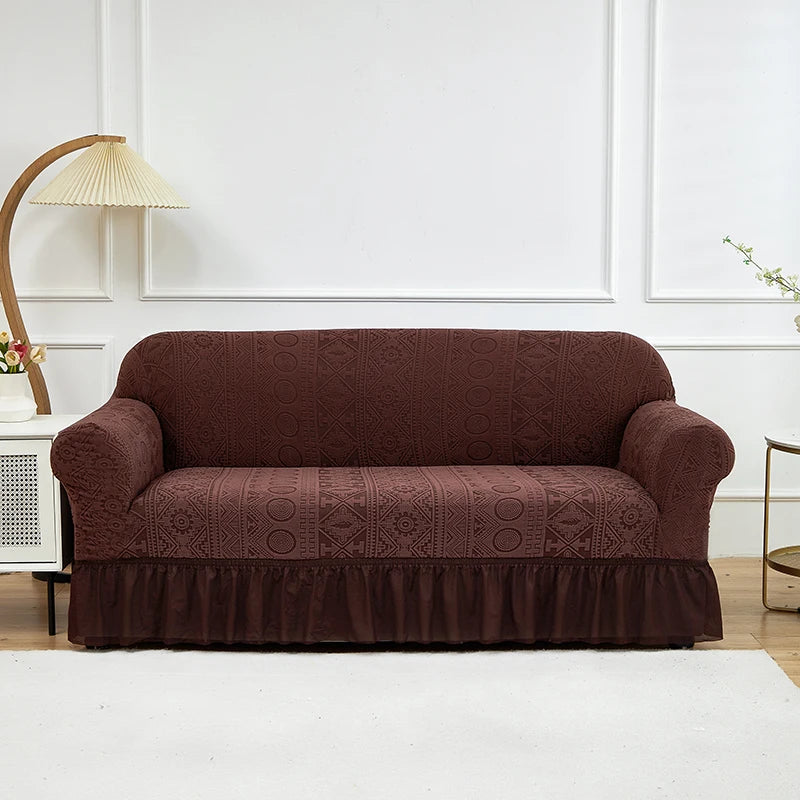 A dark brown jacquard stretch sofa cover displayed on a white sofa against a white wall.