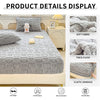 A gray plush jacquard mattress cover displayed on a bed, showing details like soft fabric and elastic bandage.