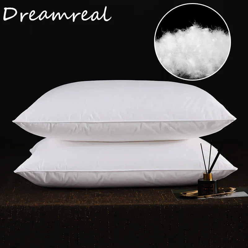 A stack of white sleeping pillows with a close-up of fluffy white down above them.