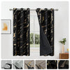 A set of two black blackout curtains featuring an elegant golden wave pattern hanging on a rod.