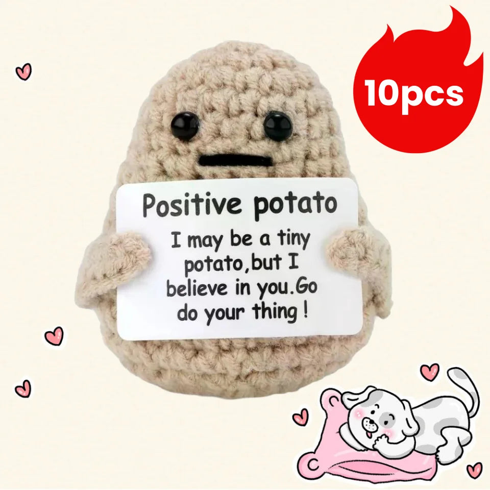 A handmade beige plush pocket doll with a white sign that reads Positive potato I may be a tiny potato but I believe in you G