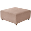 A square ottoman covered in a beige stretch jacquard fabric with a textured weave.
