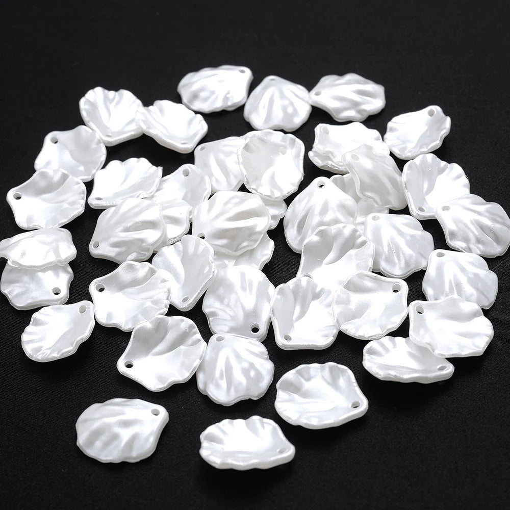 A pile of small, white imitation pearl flower spacer beads for DIY jewelry.