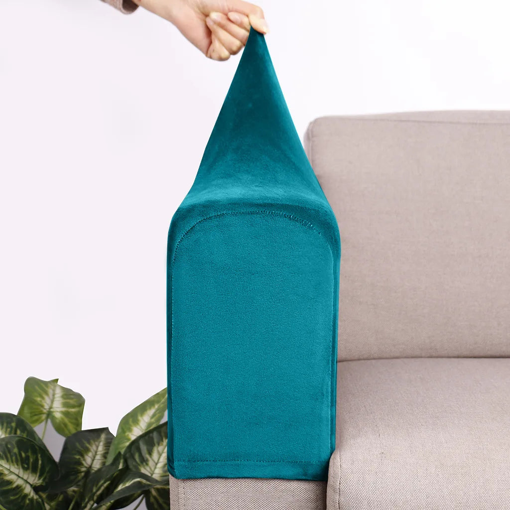 A teal velvet sofa armrest cover is being held by a hand, resting on a light-colored sofa.