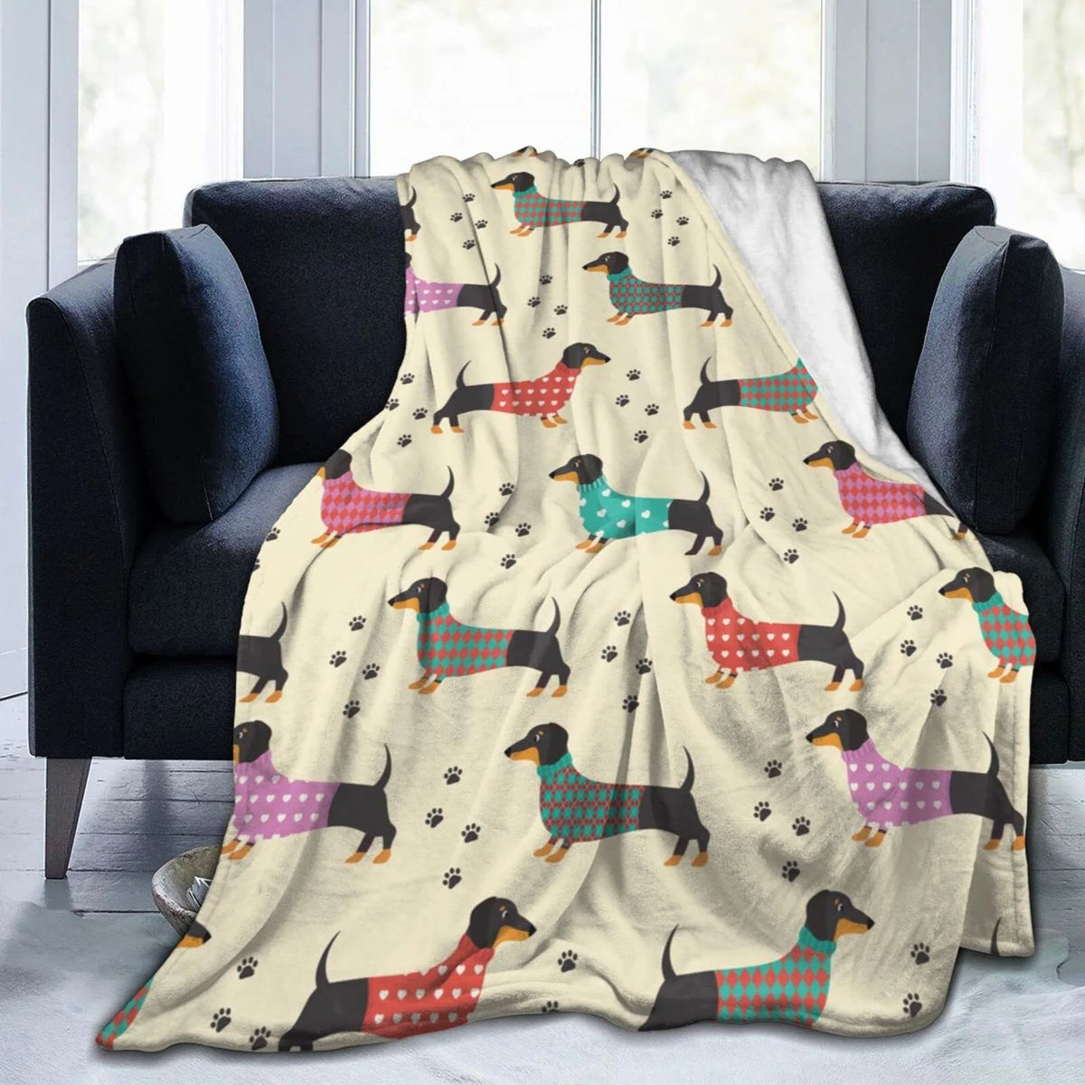 A tan flannel blanket featuring a repeating pattern of various colored dachshunds on a white background.