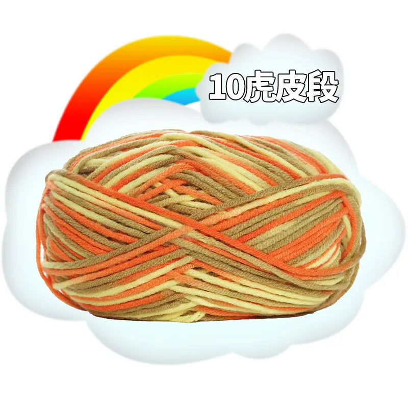 A ball of orange and beige yarn is shown emerging from a white cloud with a rainbow background.
