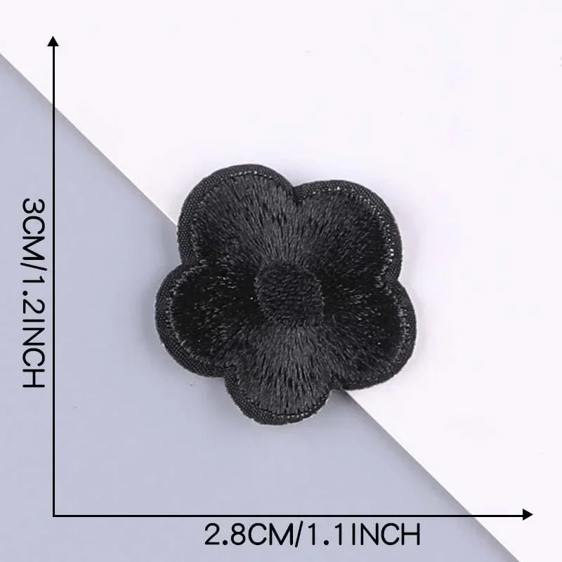 A close-up view of a black embroidered leather patch with a self-adhesive backing, shown against a white background.