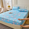 A light blue floral fitted sheet set with pink and white blossoms is displayed on a bed.