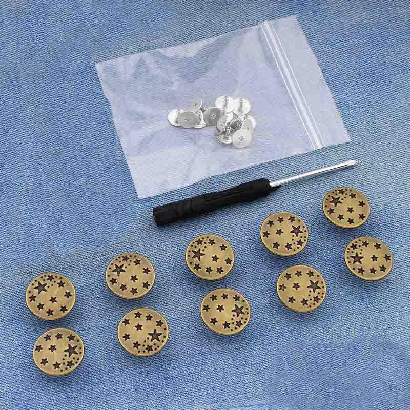 A silver metal button pin is shown resting on a white cloth with other similar pins.