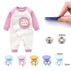 A baby-themed garment in pink and white with a round appliqué, alongside various metal sewing buttons of different sizes.