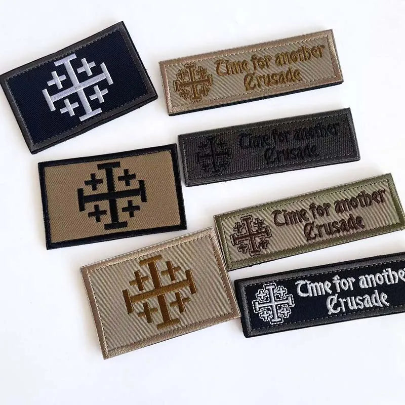 A collection of five embroidered patches featuring a cross design and the text Time for another Crusade on dark gray and tan 