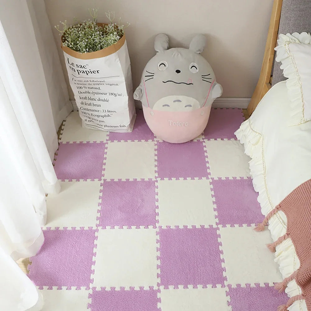 A soft plush white cat-shaped item sits on a purple and white checkered play mat with a paper bag nearby.