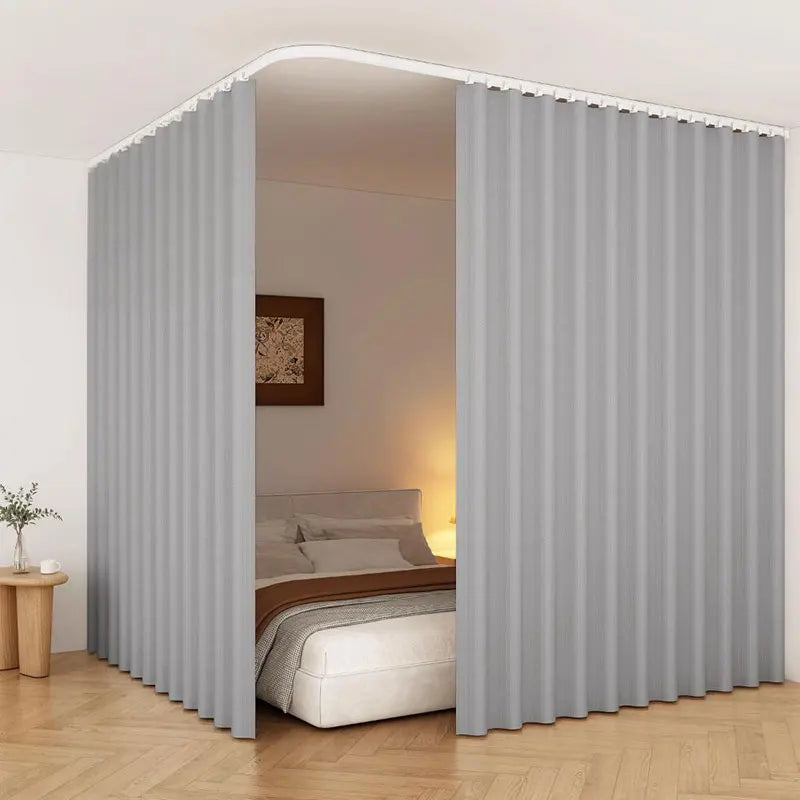 Heavy duty foldable room divider curtain in light gray fabric shown as a pleated drape framing a bedroom interior.