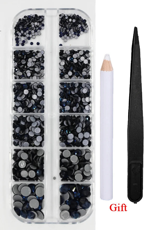 A clear plastic case containing various sizes of dark blue and silver crystal hot fix rhinestones with an applicator tool.