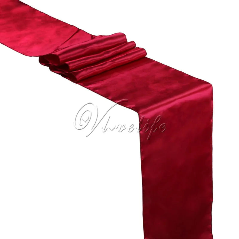 A vibrant red satin table runner draped elegantly for weddings and events.