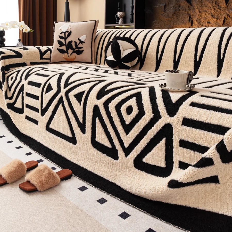 A close-up of a vintage bohemian knit sofa protector featuring black geometric patterns on a cream fabric.