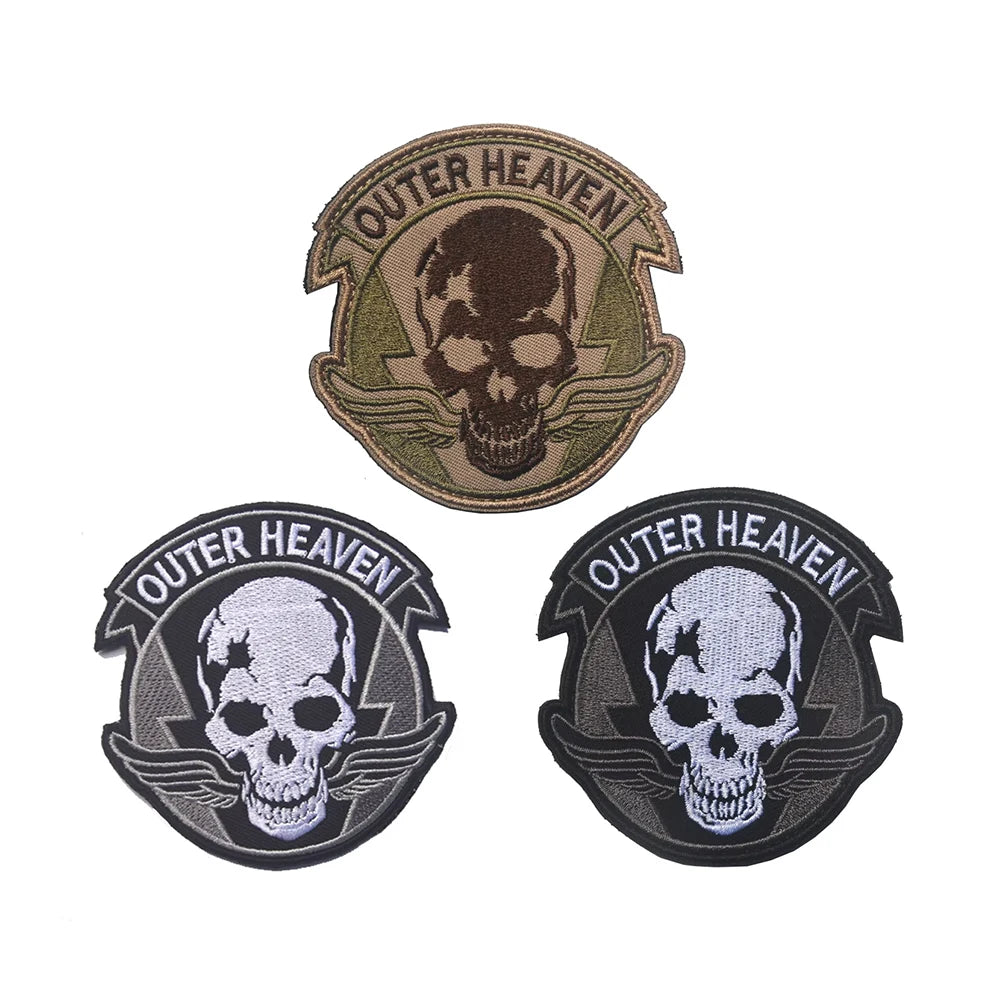 Three embroidered patches featuring a skull design with the text Outer Heaven on them.