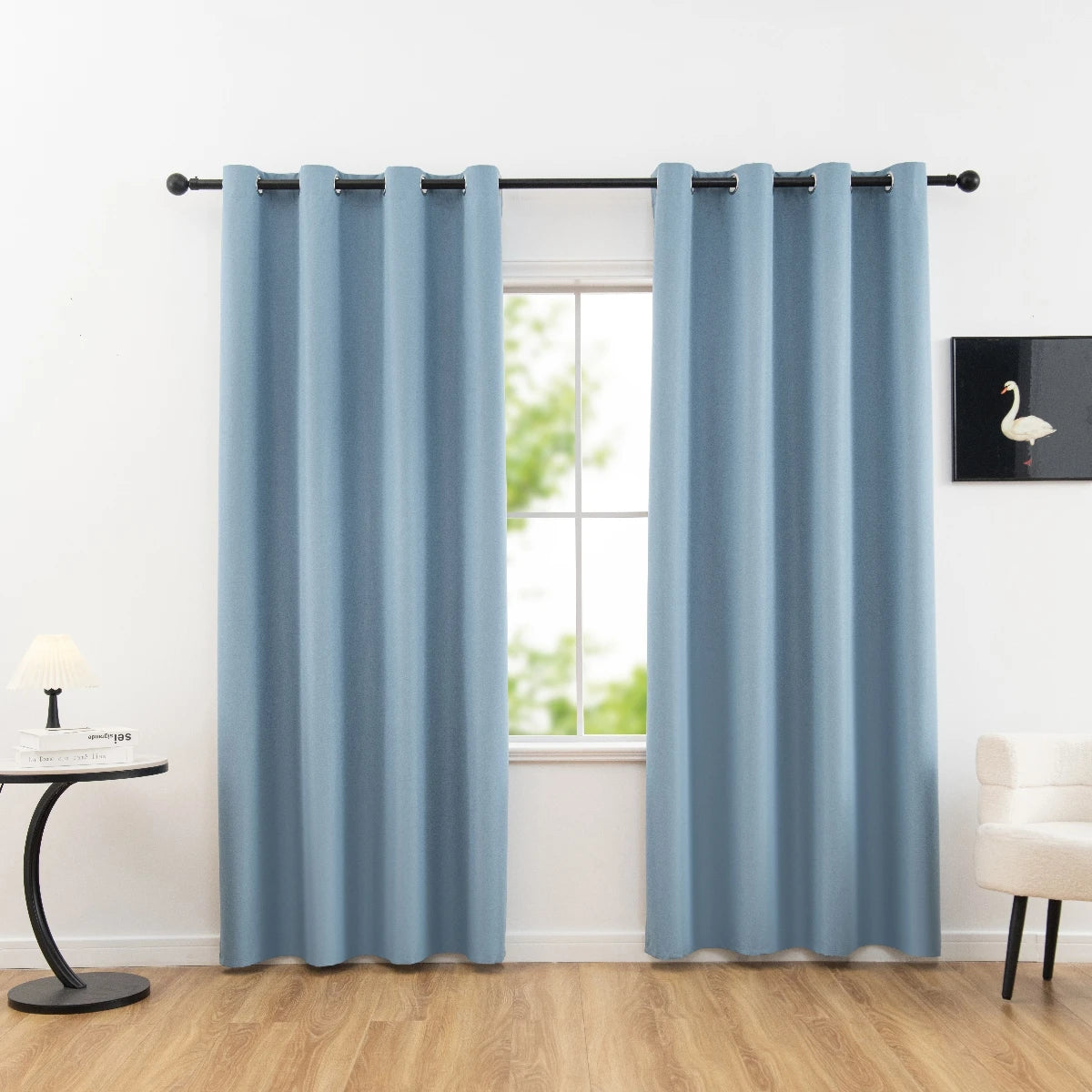 Light blue blackout privacy curtains hanging in a window frame.