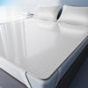A set of three white cooling ice silk sheets laid out on a bed.