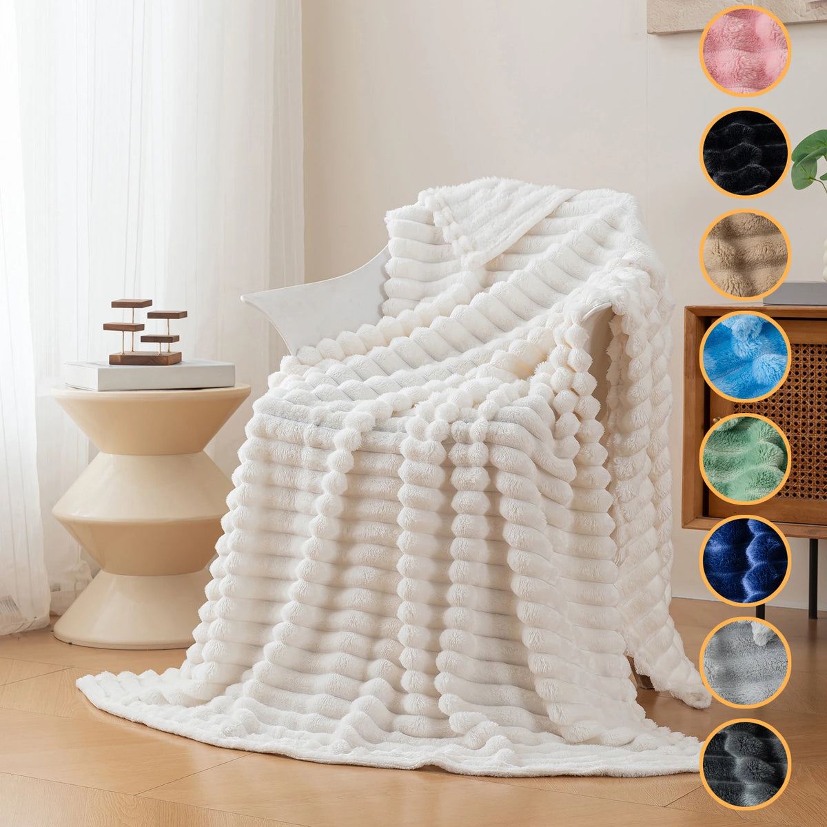 A fluffy white soft flannel throw blanket draped over a light-colored chair in a bright room.