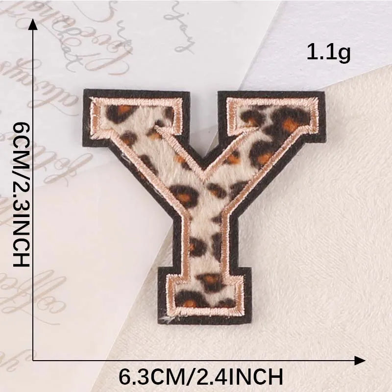 A leopard print iron-on patch shaped like the letter Y, measuring 1.1g and 6.3cm.
