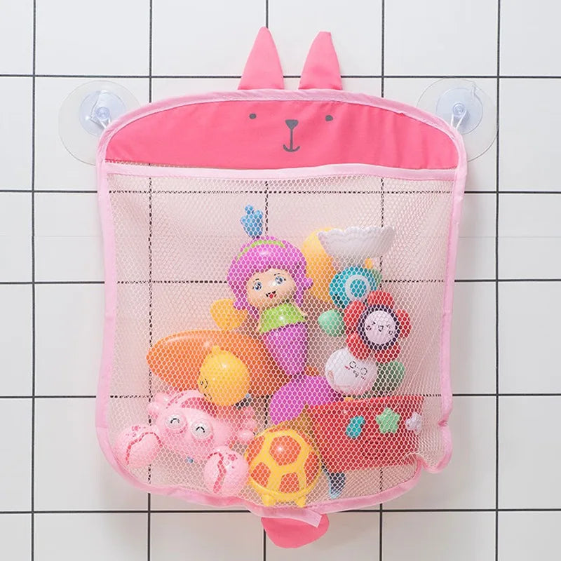 A pink mesh storage bag shaped like a cat is filled with colorful bath toys and accessories.