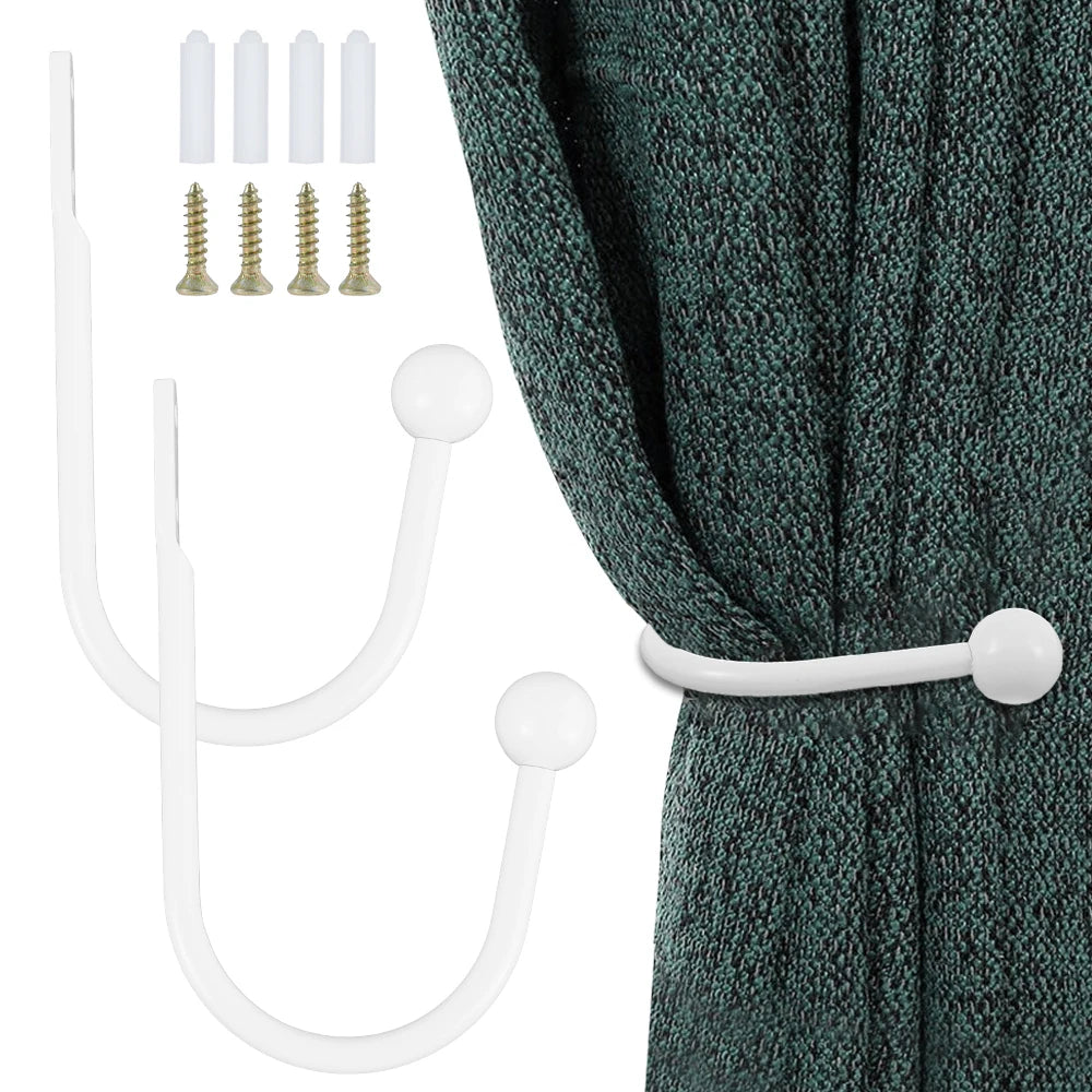 A set of white retro metal curtain holdback hooks and corresponding screws shown next to a dark teal curtain.