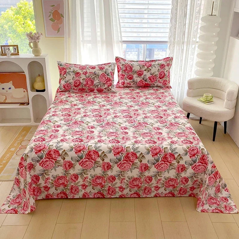 Red floral print flat bed sheets for double beds displayed on a bed.