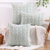 A collection of light blue and beige geometric patterned throw pillows displayed on a white surface.