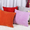 A collection of striped velvet corduroy cushion covers in shades of orange, red, purple, and gray.