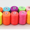 A row of ten colorful polyester sewing thread spools in various shades including orange, pink, green, and yellow.