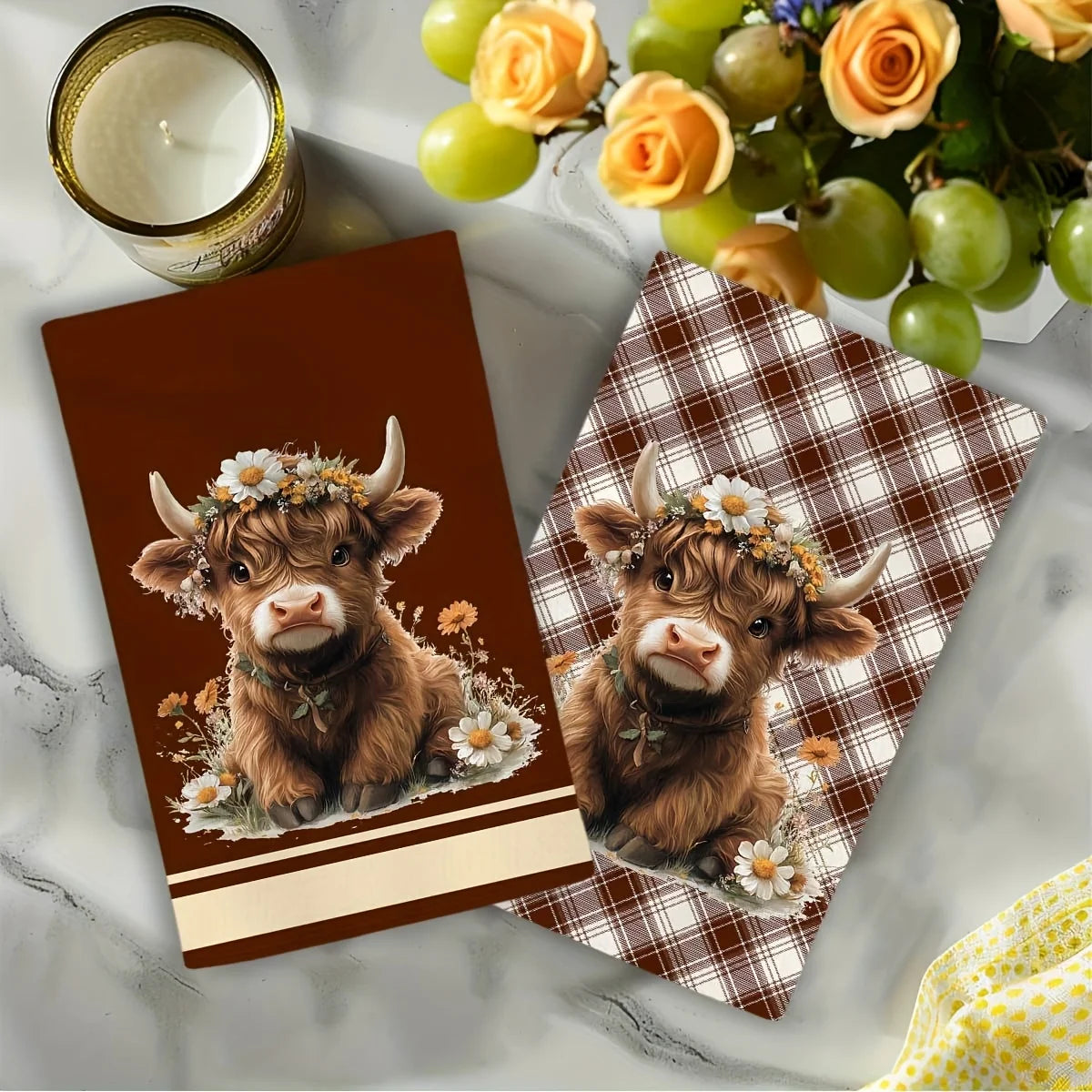 Two brown calf illustrations on plaid kitchen towels with floral accents.
