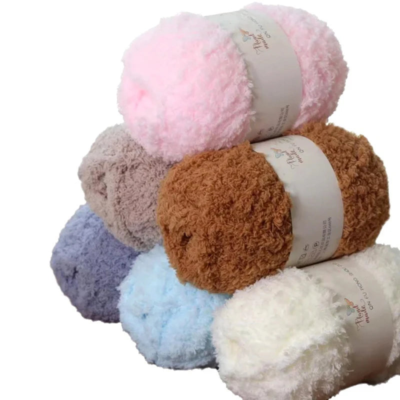 A stack of soft coral velvet yarn balls in various shades including pink, beige, and brown.