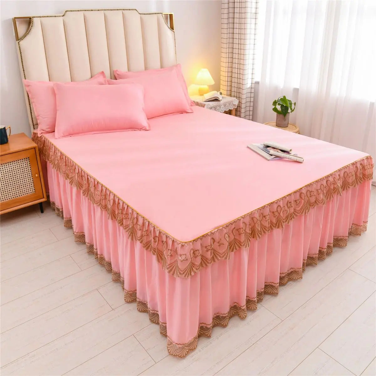 Pink luxury floral bed skirt protecting a mattress with pink bedding and pillows.