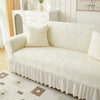 A cream jacquard elastic sofa cover featuring a textured pattern and a ruffled skirt.
