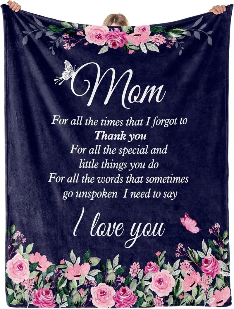 A dark blue throw blanket featuring pink and green floral embroidery with the text Mom For all the times that I forgot to tha