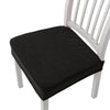 Black removable polyester bar and dining seat covers on a white wooden chair.