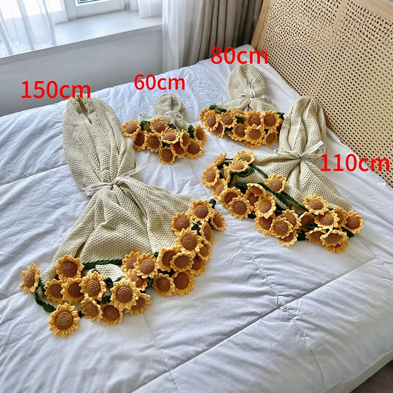 Hand knitted floral rose bouquet throw blanket displayed on a white bed with measuring tape.