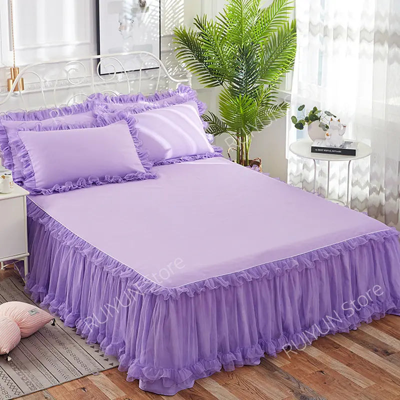 Purple princess lace bed skirt set with lilac pillows and a green plant in a bright bedroom