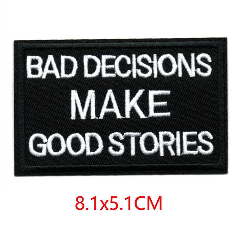 Black embroidered patch with white text that reads BAD DECISIONS MAKE GOOD STORIES