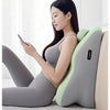 A woman is lying down and using an ergonomic prostrate pillow for stomach sleep, featuring gray and light green colors.