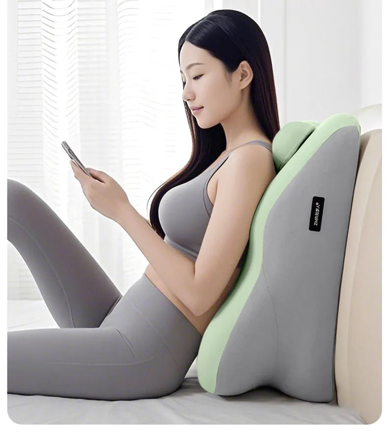 A woman is lying down and using an ergonomic prostrate pillow for stomach sleep, featuring gray and light green colors.